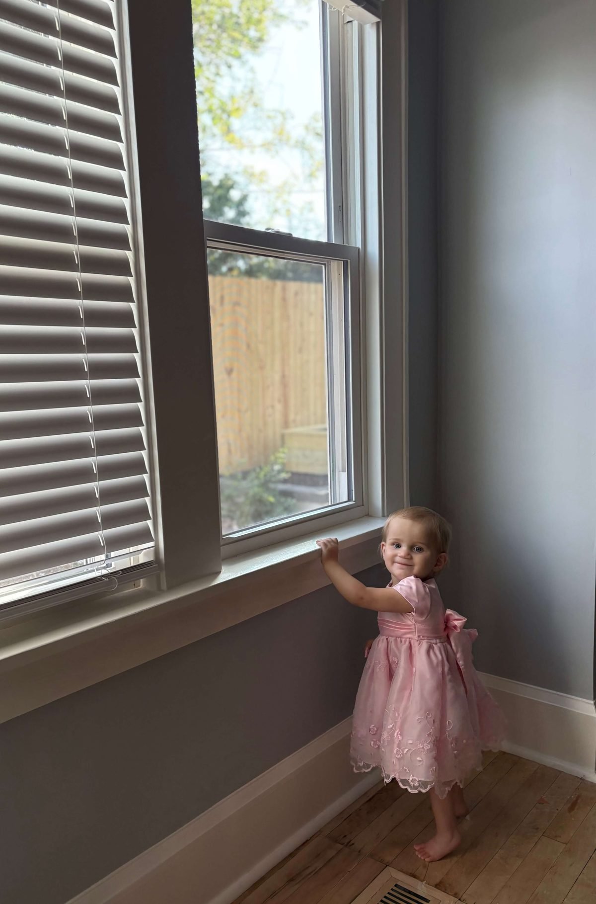 Little girl smiling by a newly installed double-hung window